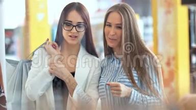 两个美女朋友在商场的店面后面讨论一些事情